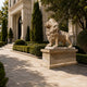 Beige marble lion roaring on its panelled plinth in a formal garden