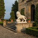 Cream marble lion with a forepaw on its sphere at a villa entrance