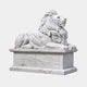White marble lion couchant on a moulded plinth, head turned out and jaws parted