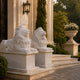 The two couchant marble lions on their pedestals at a mansion entrance