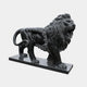 Black granite lion standing and roaring with its tail in a high loop