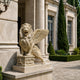 Cream marble winged lion roaring with its forepaws on the crowned block