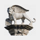 White marble winged lion with a forepaw on a carved open book