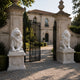 The two seated marble lions on their pedestals beside a pair of open gates