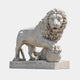 White marble lion standing with a forepaw laid over a large ball