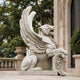White marble winged lion with one wing raised and a paw on the shield