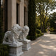 The two grey-clouded marble lions on their pedestals along a path