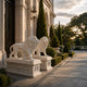 The two marble lions on their swagged pedestals at a house entrance