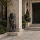 Patinated bronze lion seated on its shallow round base