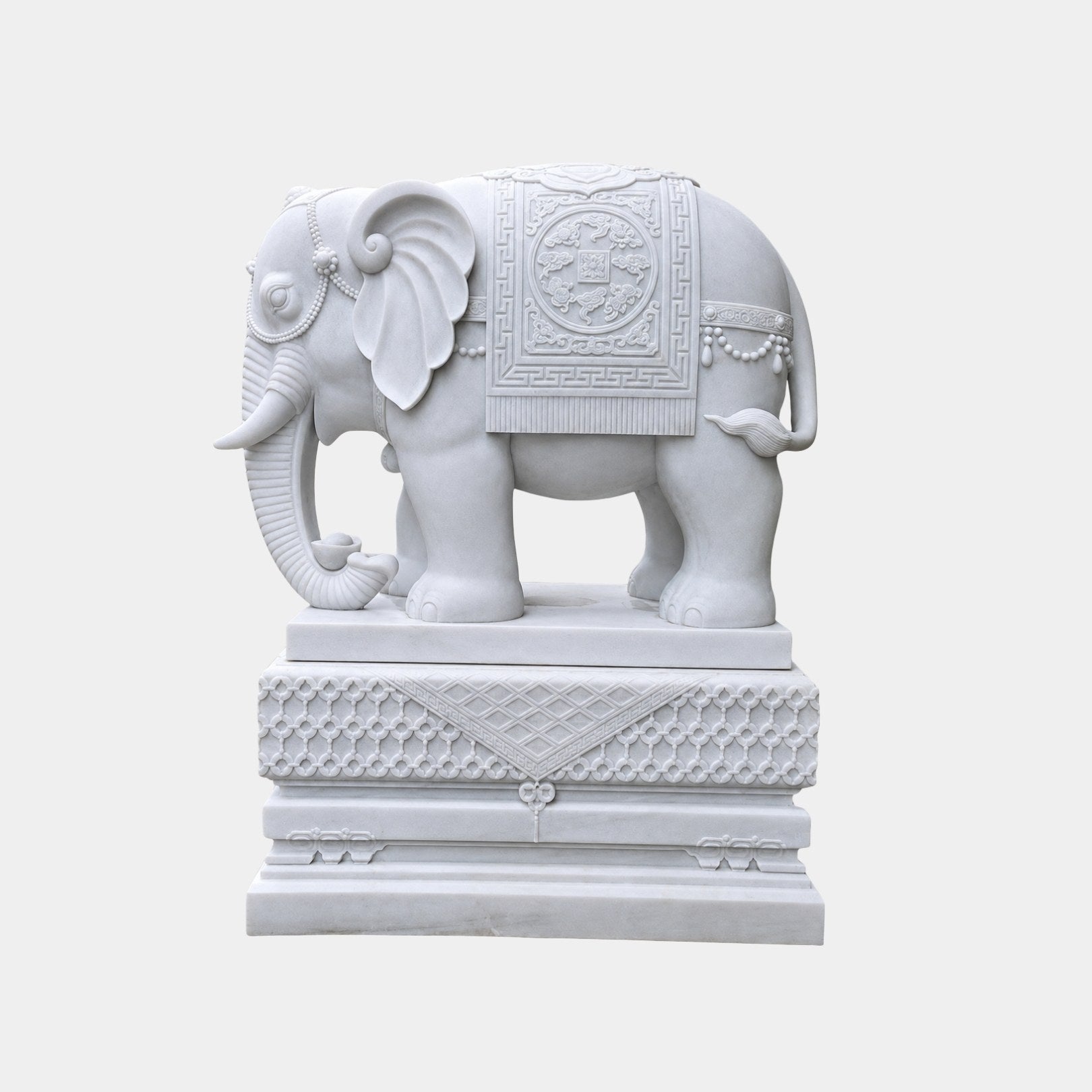 White marble caparisoned elephant standing on a lattice-carved pedestal