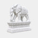 White marble elephant with a carved saddle-cloth roundel on a lotus pedestal