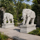 Brilliant white marble elephant with its trunk curled down holding an ingot