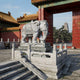 Grey granite elephant, caparisoned, in a Chinese palace courtyard