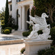 White marble Pegasus statue in a courtyard beside a fountain