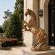 Honey-brown marble rearing horse standing beneath a stone portico