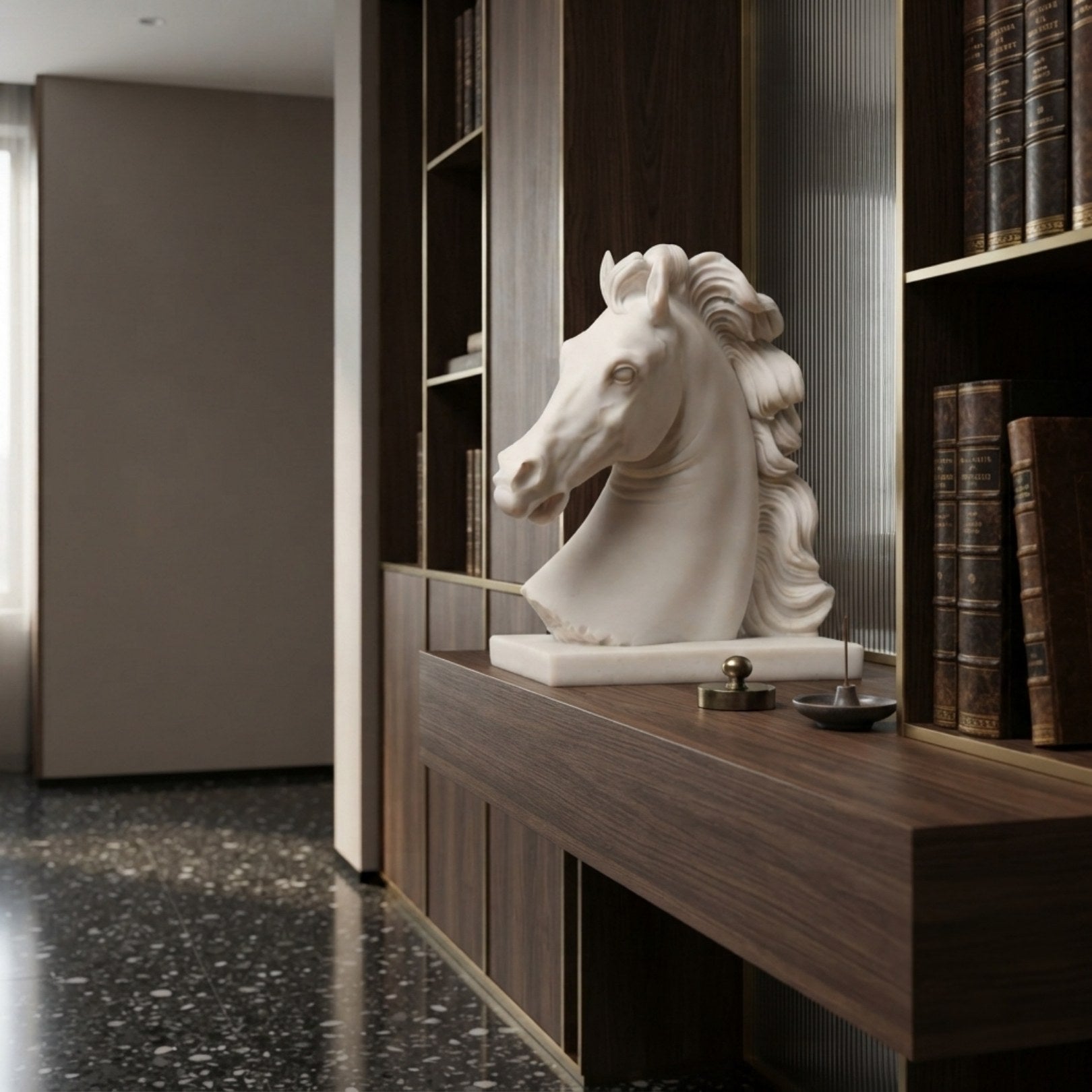 The marble horse head on a walnut shelf in a panelled library