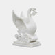 White marble swan with wings raised and a carved scroll held in its bill