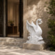 White marble swan on carved water beside a stone doorway