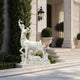 The white marble deer group on a lawn edge beside mature planting