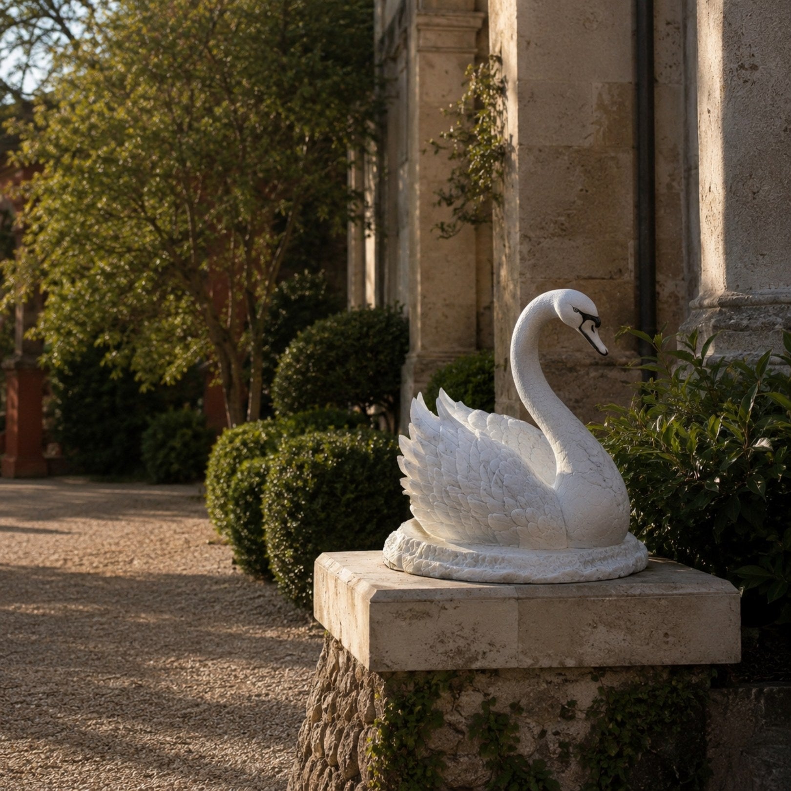 White marble resting swan shown beside a weathered classical building