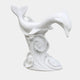 Two white marble dolphins diving over a tall column of carved breaking water