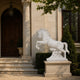 White marble leaping horse shown beside a columned stone entrance