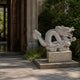 White marble dragon on its cloud-scroll plinth beside a latticed doorway