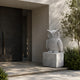 White marble owl shown beside a dark stone entrance