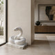 White marble coiled snake shown indoors on its veined slab