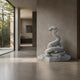 White marble rising snake shown indoors against a plaster wall