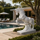 White marble leaping horse shown on its slab beside a swimming pool