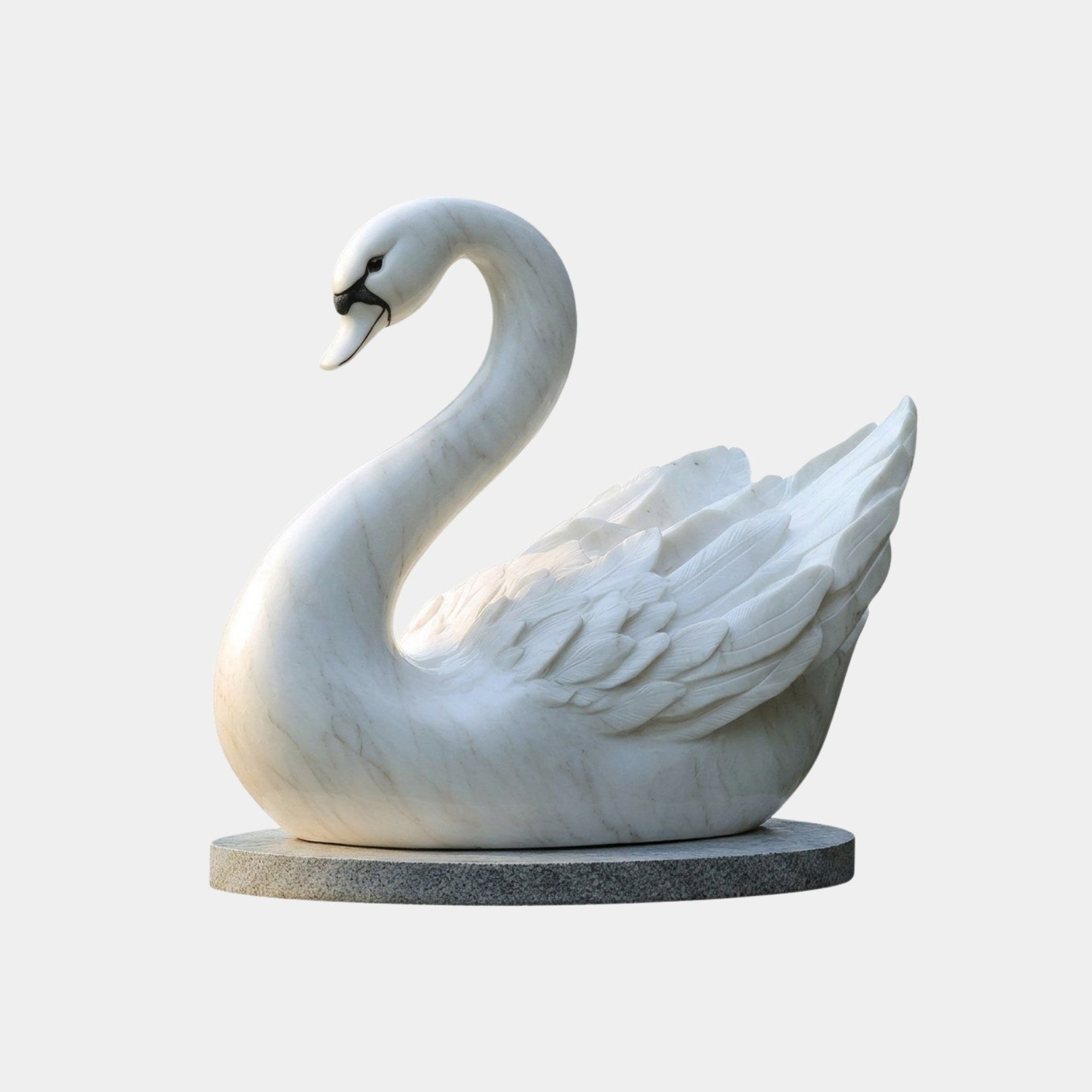 White marble swan at rest on a grey granite base plate