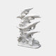 White marble group of five dolphins rising in a spiralling wave column