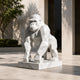 Faceted white marble gorilla on its slab in a paved forecourt