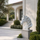 White marble horse head bust shown beside a villa portico