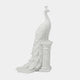 White marble peacock on a fluted column, tail carried down to the floor