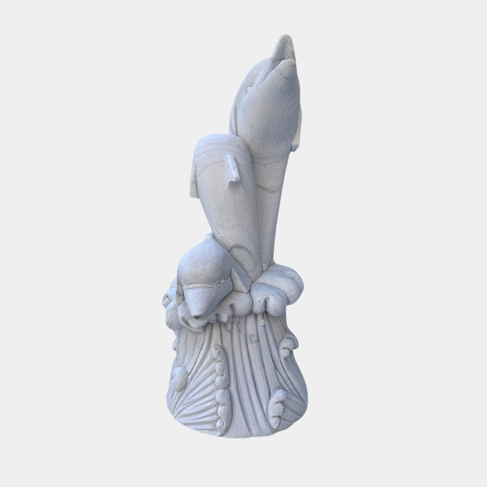 Pale grey-white marble column of three dolphins rising in a stack