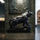 Black marble tiger shown indoors on its rock base in a gallery