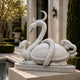 White marble snake and tortoise on their oval plinth beside a pool