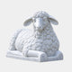 White marble sheep lying with forelegs folded, its fleece in tight spiral curls