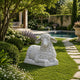 The marble sheep on a clipped lawn beside a garden pool