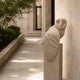 Sandstone barn owl on its own post in a limestone colonnade