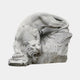 Grey granite tiger coming down over a rock with jaws open