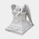 White marble weeping angel draped over a wreath-carved memorial pedestal