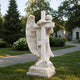 Marble weeping angel and cross memorial shown on a churchyard plot