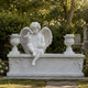 Marble child angel and doves memorial shown in a churchyard
