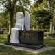 Marble angel and black granite chest memorial shown on a family plot
