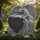 Granite angel and heart headstone shown on a cemetery plot