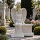 Marble seated angel bench headstone shown on a cemetery lawn
