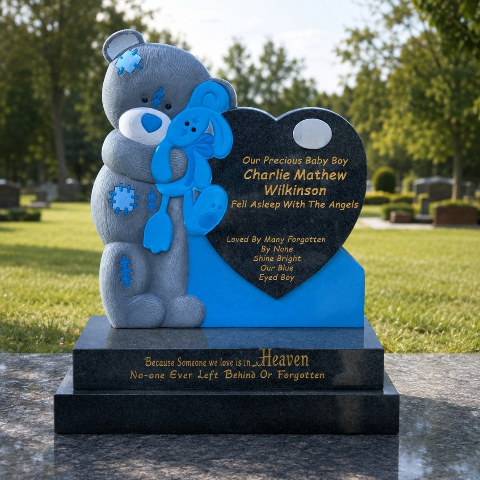 The teddy bear memorial on its granite kerb in a sunlit lawn cemetery